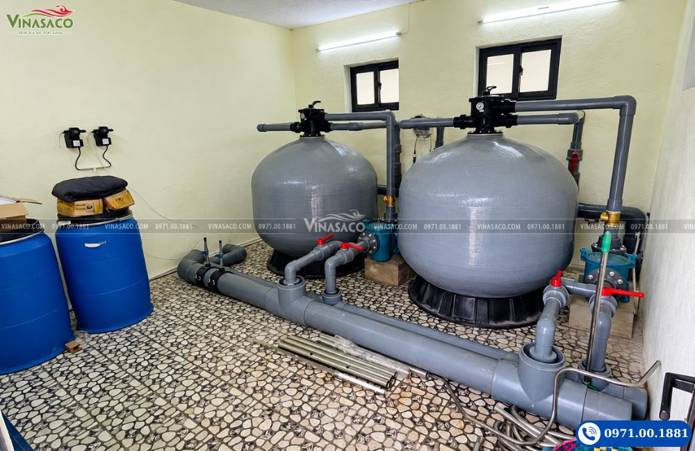 Hai bình lọc Emaux kết nối với hệ thống đường ống và van khóa trong phòng máy