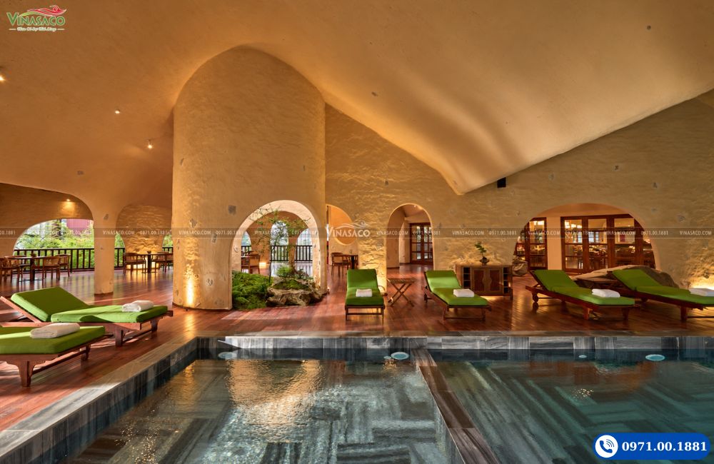 Không gian bể bơi dưới mái vòm tại The Myst Sapa Resort với ghế nghỉ bên bể