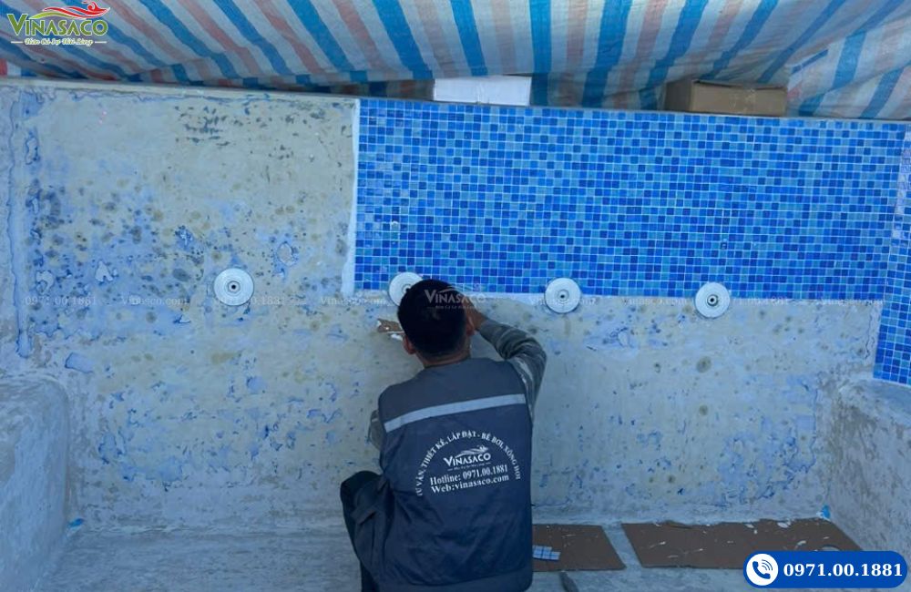 Đội thi công Vinasaco đang ốp lát gạch mosaic bể bơi theo quy trình kỹ thuật chuẩn.